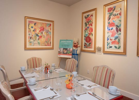 a dining room table with chairs and pictures on the wall at Roseville Commons Senior Living, Roseville, 95678