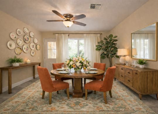 Formal dining room with orange upholstered chairs and wood credenza at Castle Vista Senior Duplex Community Apartments, Atwater, CA