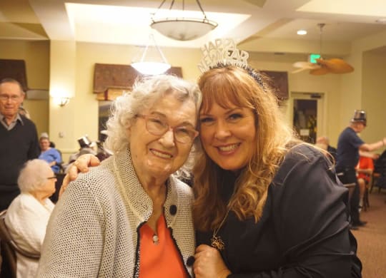 a woman with her arm around an older woman at Winding Commons Senior Living, Carmichael, California