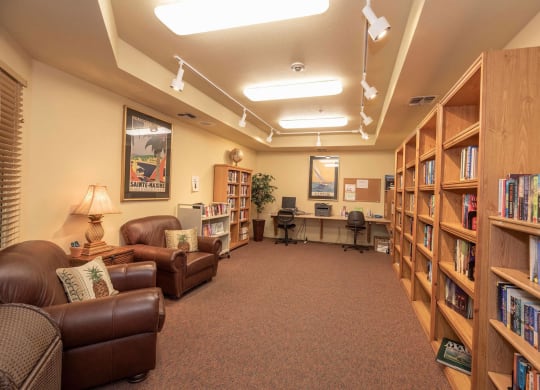 a library with furniture and shelves of books at Winding Commons Senior Living, Carmichael, CA