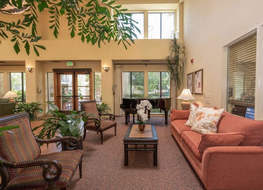 a living room with a couch and chairs and a fireplace at Winding Commons Senior Living, Carmichael, California