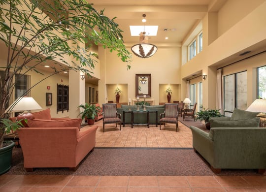 a lobby with couches and chairs and a table in the middle at Winding Commons Senior Living, Carmichael