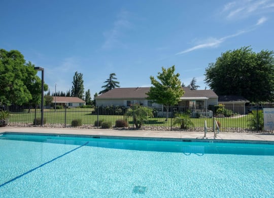 a swimming pool with a house in the background at Castle Vista Senior Duplex Community, Atwater, CA, 95301