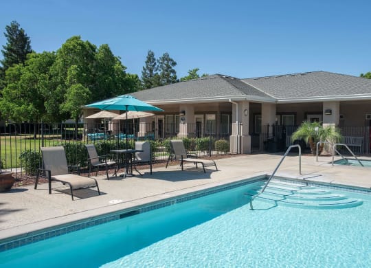a swimming pool in front of a house with a pool at Castle Vista Senior Duplex Community, Atwater