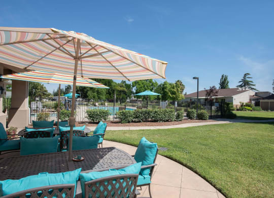 a patio with a table with chairs and an umbrella at Castle Vista Senior Duplex Community, Atwater, California