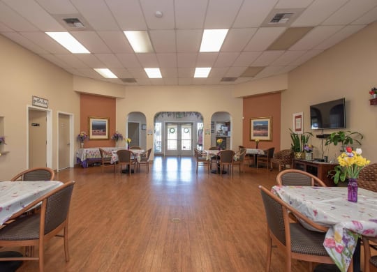 a large room with tables and chairs and a wood floor at Castle Vista Senior Duplex Community, Atwater, CA
