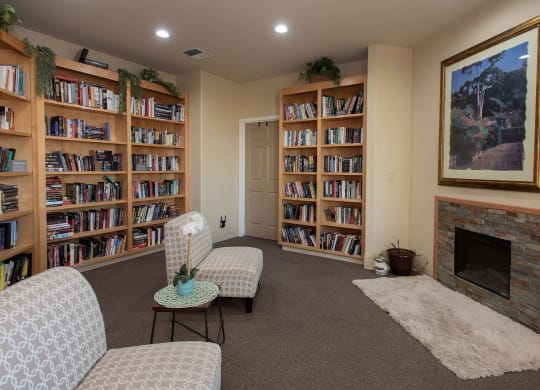 a living room with a fireplace and shelves of books at Castle Vista Senior Duplex Community, Atwater, 95301