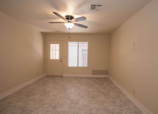 an empty living room with a ceiling fan and a window at Castle Vista Senior Duplex Community, Atwater, CA, 95301