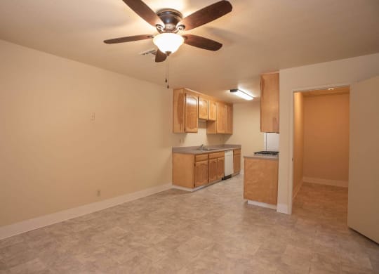 an empty living room with a ceiling fan and a kitchen at Castle Vista Senior Duplex Community, Atwater, California