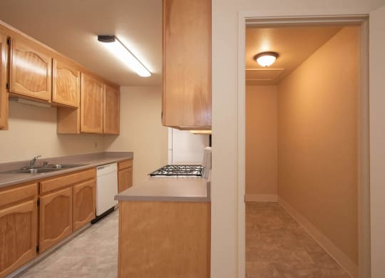 a view of a kitchen with wood cabinets and a white stove and sink at Castle Vista Senior Duplex Community, Atwater, CA