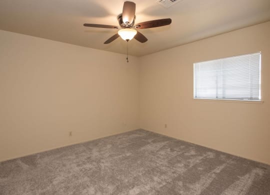 an empty living room with a ceiling fan and a window at Castle Vista Senior Duplex Community, Atwater, CA
