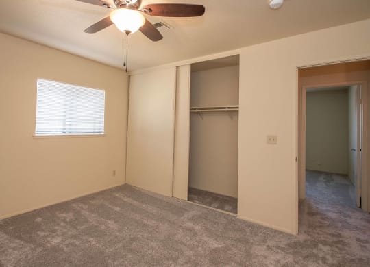 an empty living room with a ceiling fan and a closet at Castle Vista Senior Duplex Community, Atwater, CA