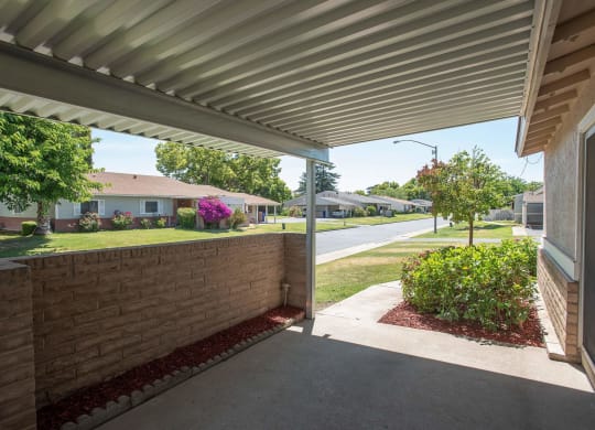 a covered porch with a view of a street and some houses at Castle Vista Senior Duplex Community, Atwater, 95301