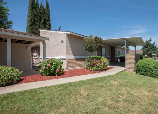 a building with a porch and a lawn in front of it at Castle Vista Senior Duplex Community, Atwater, CA, 95301