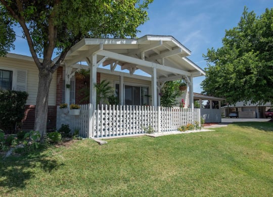 a house with a white porch and a white picket fence at Castle Vista Senior Duplex Community, Atwater, 95301