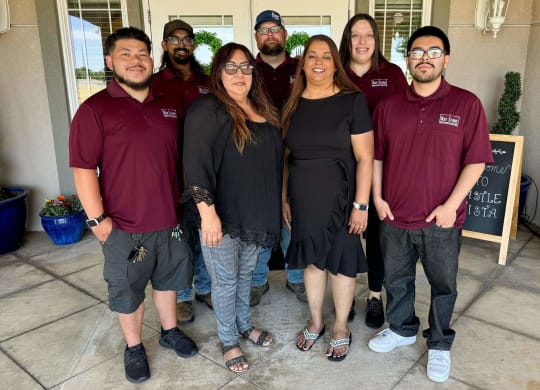 a group of people posing for a picture in front of a building at Castle Vista Senior Duplex Community, Atwater