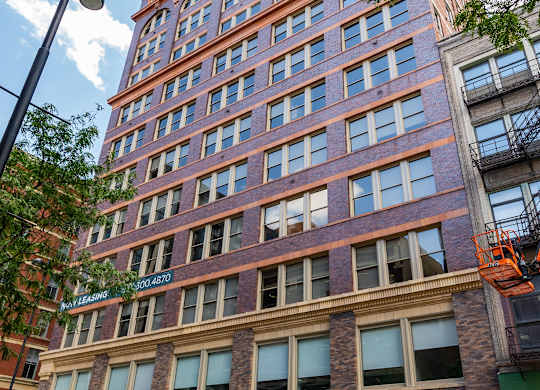 a tall brick building with cars parked in front of it at Textile Apartments, Ohio