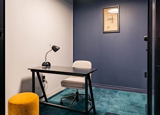 a room with a desk and a chair and a lamp at Textile Apartments, Ohio