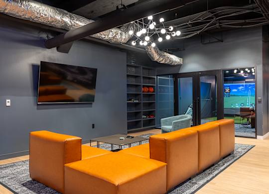 a living room with orange couches and a television at Textile Apartments, Cincinnati, 45202