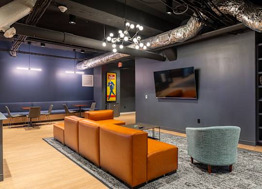 a lobby with couches and chairs and a tv at Textile Apartments, Cincinnati, OH