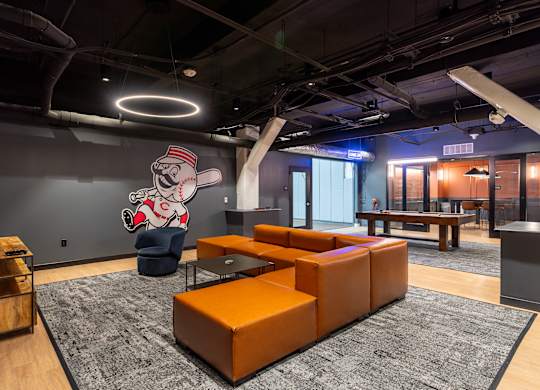 a lobby with orange couches and a mural of a baseball player at Textile Apartments, Cincinnati, OH, 45202