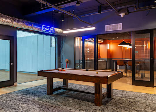 a pool table in a room with glass doors at Textile Apartments, Ohio