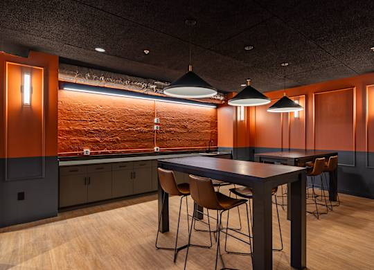 a dining room with a table and chairs and lamps at Textile Apartments, Cincinnati, OH