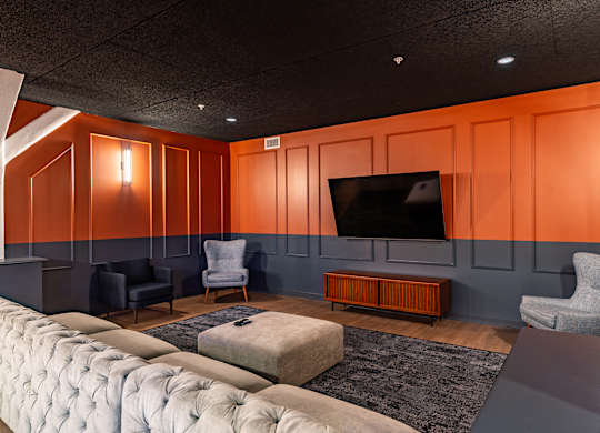 a living room with orange walls and a television at Textile Apartments, Cincinnati, 45202