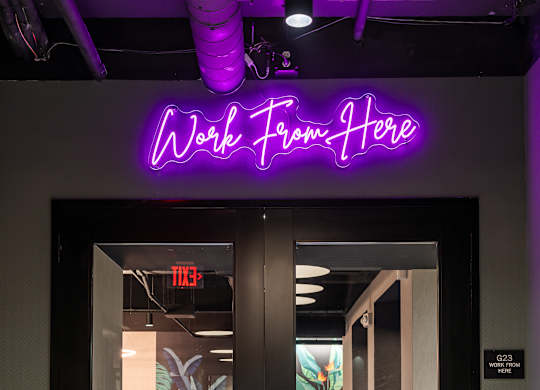 a purple neon sign above a door that reads work from home at Textile Apartments, Cincinnati, OH