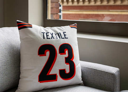 a pillow with the number 23 on it sitting on a couch next to a window at Textile Apartments, Cincinnati, Ohio