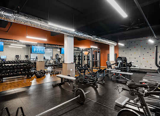 a gym with weights and cardio equipment and a rock climbing wall at Textile Apartments, Ohio