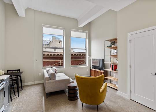 a living room with a couch and a chair and a window at Textile Apartments, Cincinnati, 45202