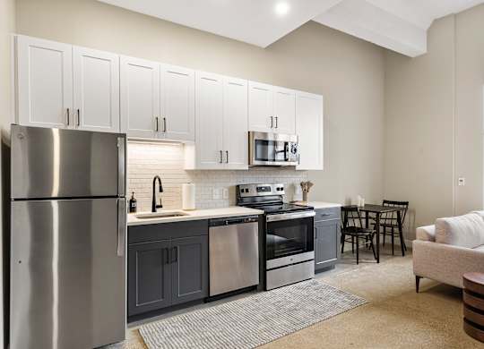 a kitchen with stainless steel appliances and white cabinets at Textile Apartments, Cincinnati, OH