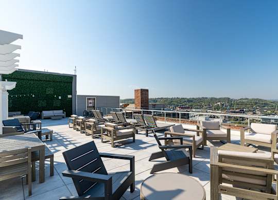 a roof top patio with tables and chairs and a view of the city at Textile Apartments, Cincinnati, Ohio