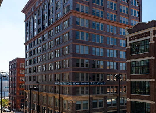 a tall brick building with a street in front of it at Textile Apartments, Cincinnati, OH