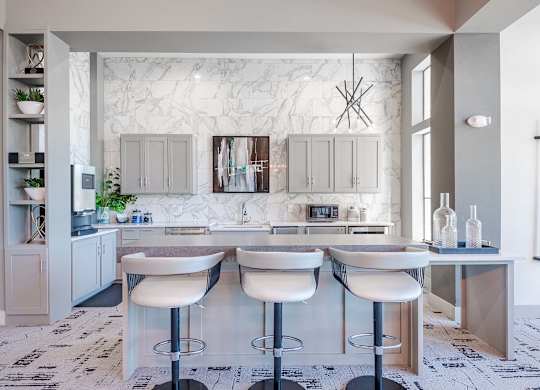 a white kitchen with a bar and white counter tops at Discovery at Craig Ranch, McKinney, Texas