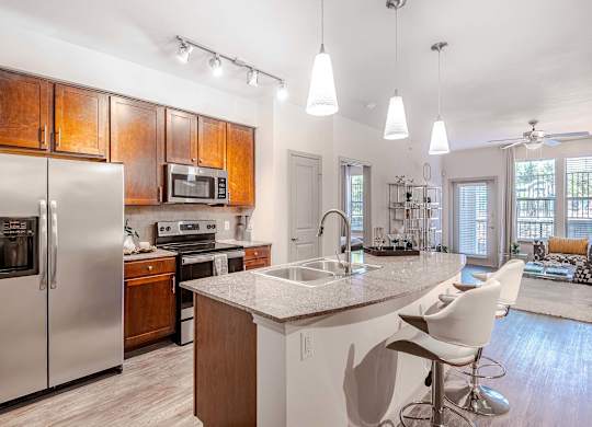 a kitchen with a island and a stainless steel refrigerator at Discovery at Craig Ranch, McKinney