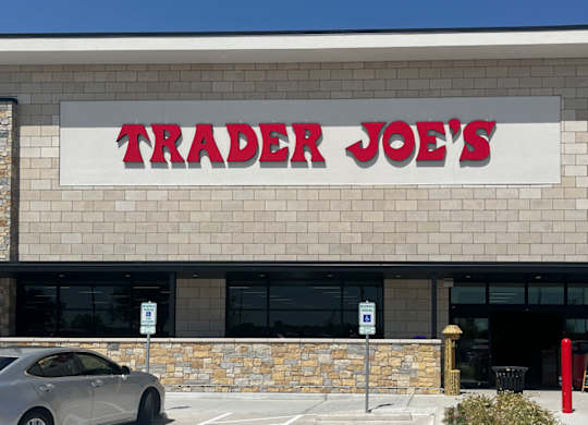 A grey car is parked in front of a Trader Joe's store at Discovery at Craig Ranch, McKinney, 75070.