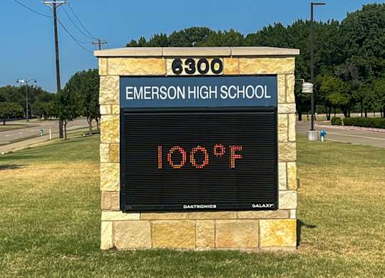 A sign at Emerson High School displays the temperature of 100 degrees Fahrenheit at Discovery at Craig Ranch, McKinney, TX