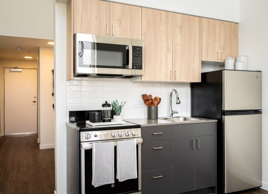 a small kitchen with stainless steel appliances and a microwave