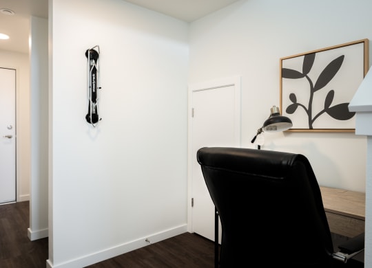 an office space with a black leather chair and a white wall with a bike rack
