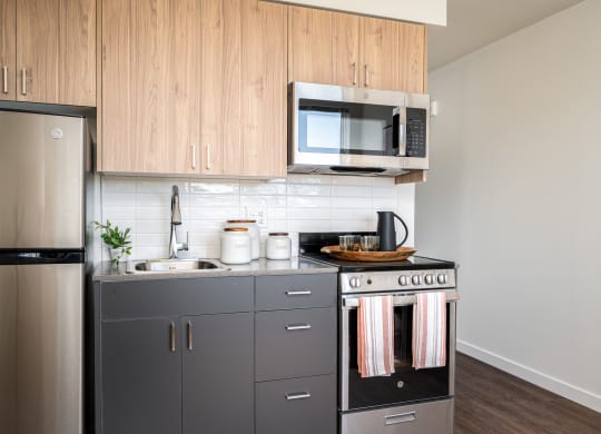 kitchen with stainless steel refrigerator, microwave, stove, and two-tone wood cabinetry