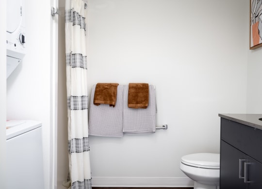 a bathroom with two towels and a toilet and a shower curtain