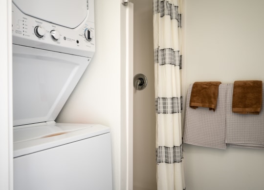 bathroom with shower and stacked washer and dryer