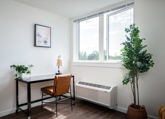 Room with large window, air conditioner, desk and chair