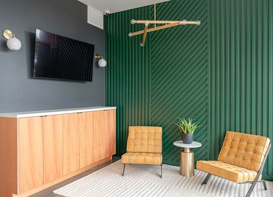 A room with a green wall and a wooden reception desk.