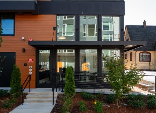 the front of a building with glass doors and a staircase