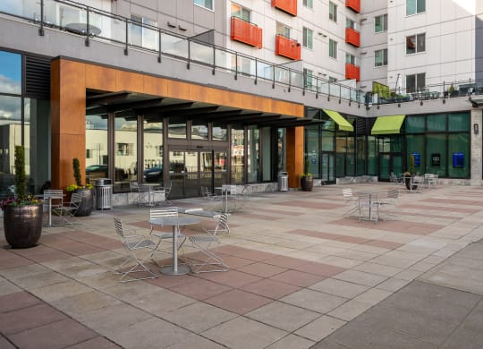 a courtyard with tables and chairs outside of a building