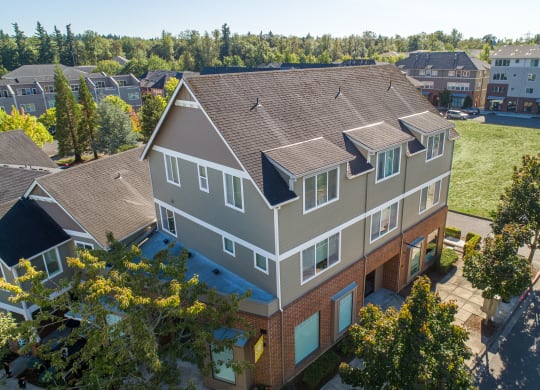 an aerial view of a house with a green lawn and trees