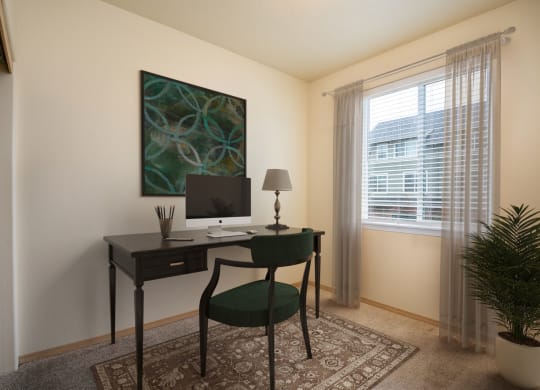 a room with a desk with a computer and a chair